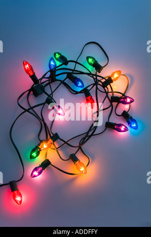 Un brin de grandes lumières d'arbre de Noël avec cordon noir sur blanc enroulé grisé background studio portrait Banque D'Images