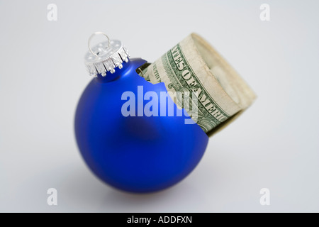 Libre d'un arbre de noël ornement bleu ampoule cassée avec des dollars à l'intérieur de peeking out on white background studio portrait Banque D'Images