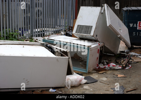 Réfrigérateurs et congélateurs abandonnés dans une ruelle derrière un défilé de boutiques Banque D'Images