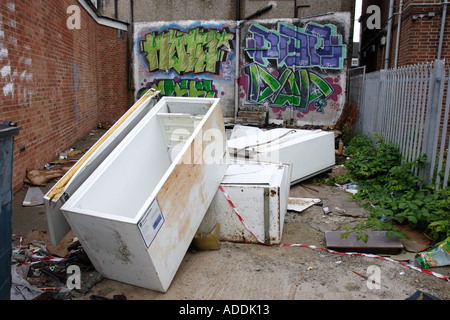 Réfrigérateurs et congélateurs abandonnés dans une ruelle derrière un défilé de boutiques Banque D'Images