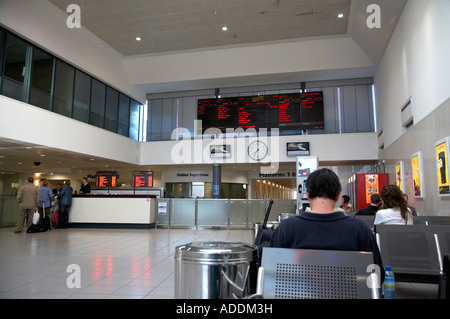 Les passagers qui attendent et calendrier principal bord tôt le matin, la gare centrale de Belfast Banque D'Images