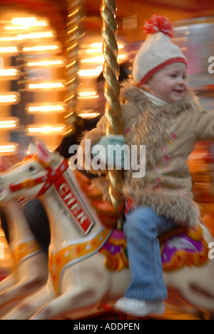 Petit garçon Jouet à l'équitation sur un carrousel, fête foraine, George Square, la veille de Noël. Glasgow.L'Ecosse. Déc Banque D'Images