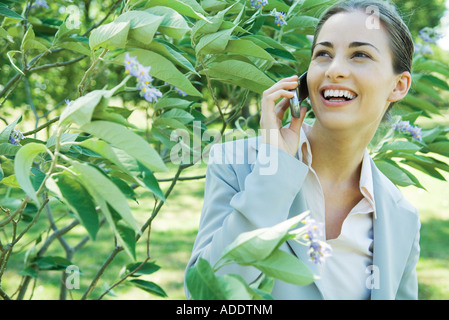 Businesswoman using cell phone, smiling Banque D'Images