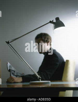 L'homme à la table reading magazine Banque D'Images