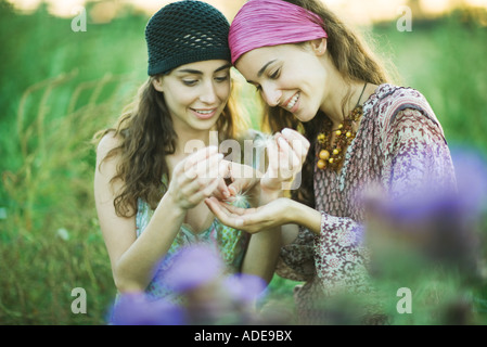 Les jeunes femmes hippie à la recherche de graines de pissenlit Banque D'Images