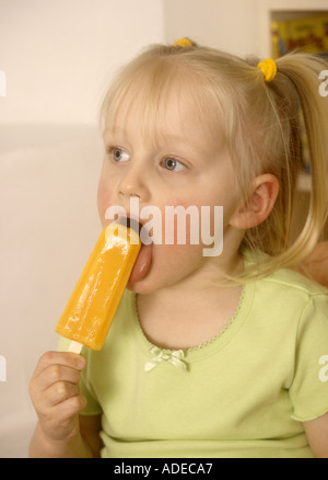 Une jeune fille suce un lacé de glace, des sucettes glacées, des vagues de chaleur britanniques Banque D'Images