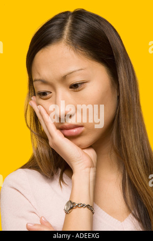 Jeune femme s'inquiète de ses dents. Banque D'Images