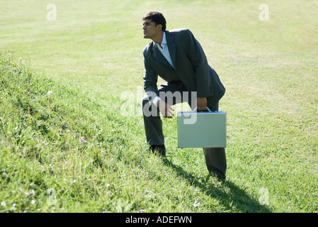 Businessman holding briefcase, debout sur la colline parlementaire Banque D'Images
