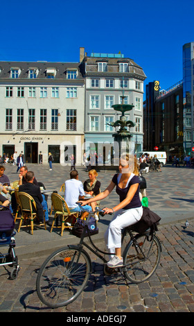 Une femme équitation son vélo à Hojbro Plads square dans le centre de Copenhague Danemark EU Banque D'Images