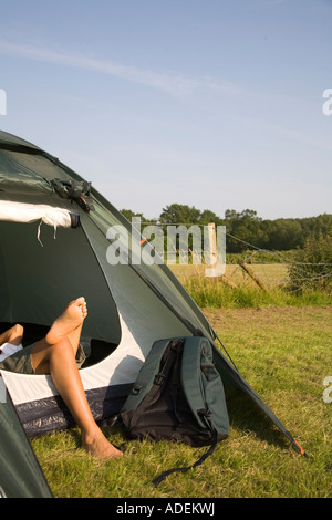 Une femme de vous détendre dans une tente dans la New Forest, en Angleterre. Banque D'Images