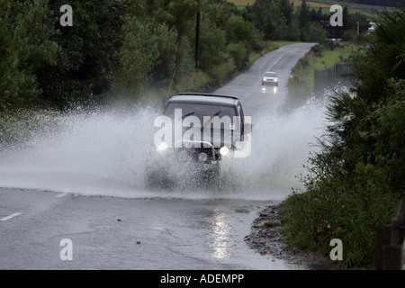 Par éclaboussures voiture route inondée après de fortes pluies près de Turriff, Aberdeenshire, Scotland, UK Banque D'Images