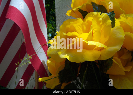 Old weathered de pierres tombales dans un cimetière de la Nouvelle Angleterre pittoresque fleurs artificielles et le drapeau américain Banque D'Images