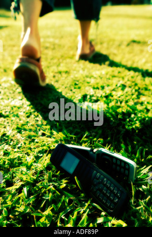 Personne anonyme laissant derrière eux un couple de téléphones cellulaires. Point de vue faible. Banque D'Images