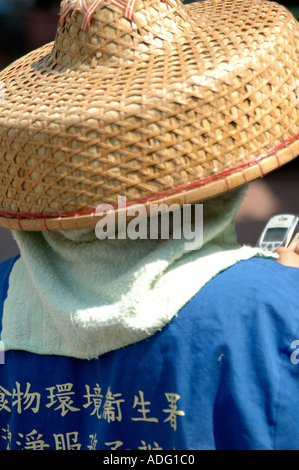 Femme chinoise nettoyant de rue utilisant son ancien téléphone mobile Nokia. L'île de LAMMA juste à côté de Hong Kong, Chine, Banque D'Images