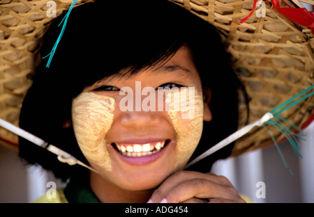 Pretty smiling young girl in bamboo hat à la pagode Shwedagon à Yangon, Birmanie,avec Tanaka traditionnelle écorce coller sur son visage Banque D'Images