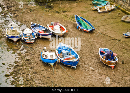 Petits bateaux de pêche échoués à marée basse Staithes Yorkshire Coast Banque D'Images