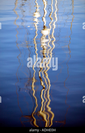 Réflexions de mâts yacht déformée dans l'eau Port Vell de Barcelone Catalogne Espagne Banque D'Images
