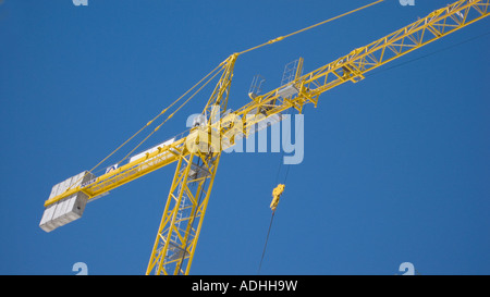 Grue à tour jaune contrastant contre un ciel bleu Banque D'Images