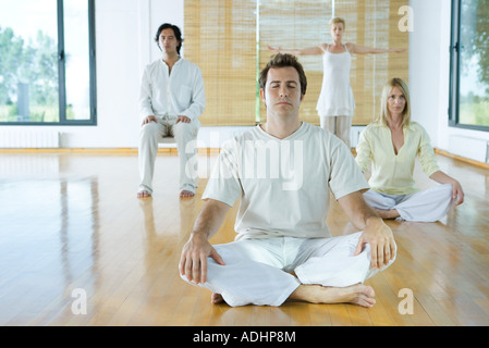 Méditation en groupe, les adultes assis dans des positions différentes Banque D'Images