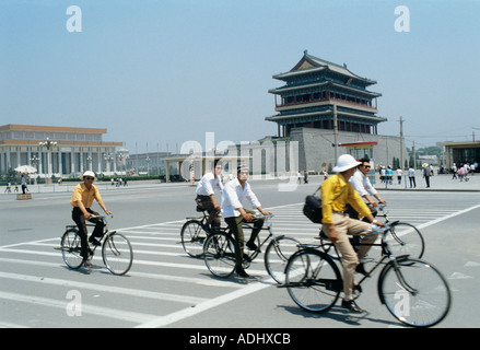 Les cyclistes de Pékin passent devant une porte de la vieille ville. En arrière-plan se trouve la tombe de Mao Tse Tung Banque D'Images