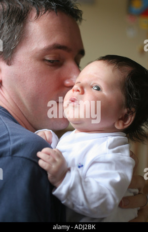 3 semaine Baby Boy étant tenu par son Père Wales UK Banque D'Images