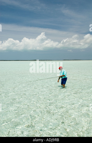 Une plus grande BAHAMA EXUMA pêcheur de mouche de patauger dans la mer vert émeraude pour moulage de Bonefish appartements Océan Atlantique Banque D'Images