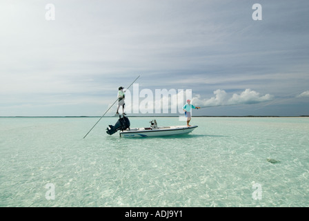 Une plus grande BAHAMA EXUMA Fly fisherman casting pour les os des poissons dans les eaux vert émeraude. Banque D'Images