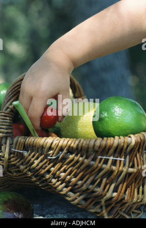 Pour atteindre l'enfant en fruits panier plein de produits frais Banque D'Images