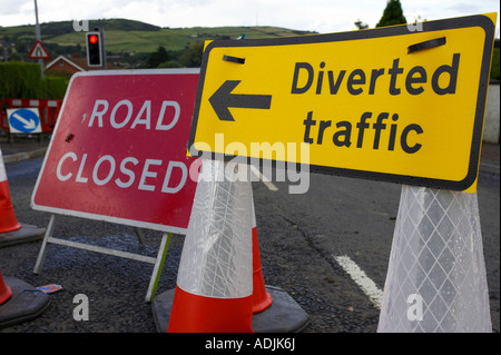 Road closed sign et jaune détourné signe de la circulation sur les cônes de circulation en raison de travaux de voirie sur la rue résidentielle dans newtownabbey Banque D'Images