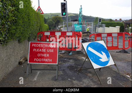 Les piétons veuillez utiliser d'autres sentier et flèche bleue signe en travaux sur rue dans newtownabbey Banque D'Images