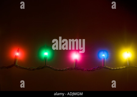 Un brin de couleur blanc multi lumières d'arbre de Noël qui brille dans les étoiles dark studio portrait Banque D'Images