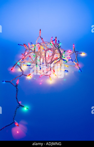 Un brin de lumières d'arbre de Noël multicolores avec boudin noir teinte bleue studio portrait Banque D'Images