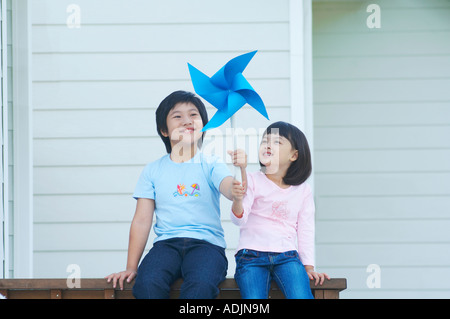 Un heureux frère et soeur tenant un soleil avec un sourire Banque D'Images
