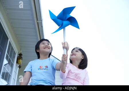 Un heureux frère et soeur tenant un soleil avec un sourire Banque D'Images