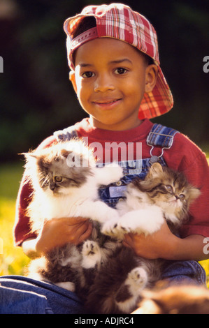 Portrait of a Boy holding cats Banque D'Images