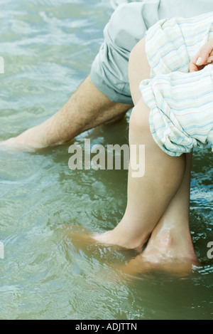Deux pieds qui pendent dans l'eau, cropped view Banque D'Images