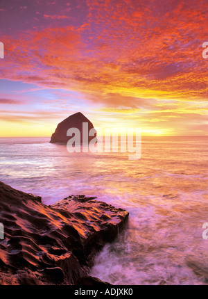 Coucher du soleil à Cape Kiwanda avec vague couverts rock Oregon Banque D'Images