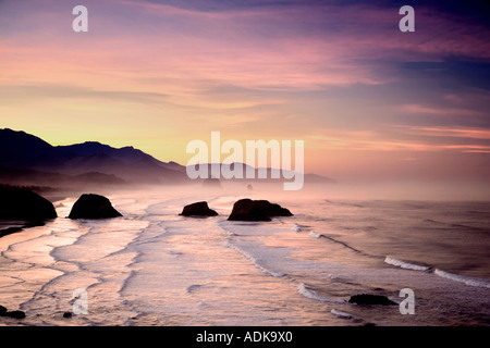 Lever du soleil et nuages avec des vagues Cannon Beach Oregon Banque D'Images