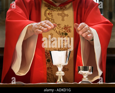 Un prêtre Anglican consacre le pain et le vin à l'Eucharistie Banque D'Images