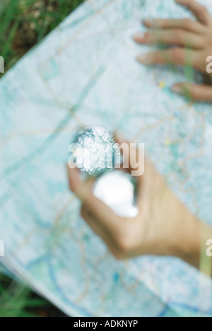 Personne étudiant la carte et boussole holding, portrait de mains, defocused Banque D'Images