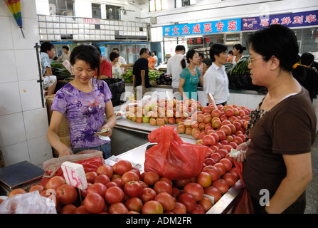 Une femme achète les tomates dans un marché d'alimentation à Beijing, en Chine, 13 août 2007 Banque D'Images