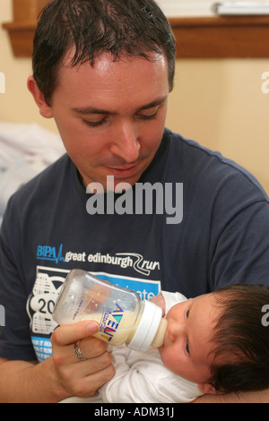 3 semaine Baby Boy bouteille étant alimenté par son Père Wales UK Banque D'Images