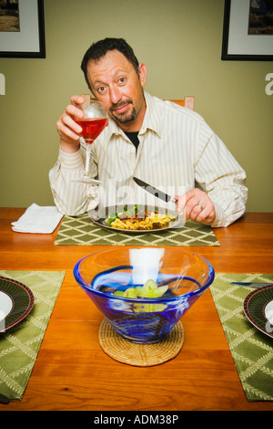 Portrait de l'homme de boire du vin et de manger le dîner Banque D'Images