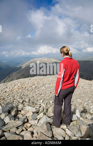 Walker sur le cairn au sommet du plus haut pic Scafell Pike en Angleterre Parc National de Lake District Cumbria England Banque D'Images