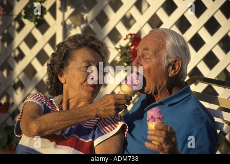 Fun loving attractive Senior citizen citoyens 70 couple sharing ice cream cones personne personnes jeunes de cœur monsieur © myrleen pearson Banque D'Images