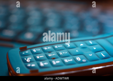 Closeup détail d'un téléphone cellulaire numérique et un clavier d'ordinateur portable Banque D'Images