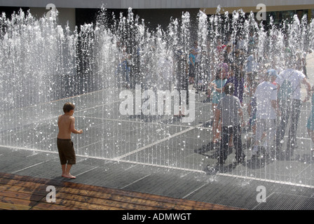 Londres Southbank apparaissant Chambres fontaine pour les enfants debout dans d'essayer de rester sec ou pour se rafraîchir Rive Sud Royal Festival Hall UK Banque D'Images
