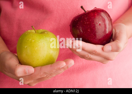 Deux femmes mûres mains tenant les pommes delicious rouges et verts Banque D'Images