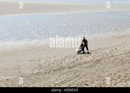 Homme avec poussette sur plage de l'estuaire de l'Afon Dwyryd près de Portmeirion Portmerion et Harlech dans le Nord du Pays de Galles Banque D'Images