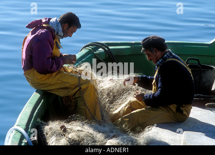 Les pêcheurs réparer leurs filets de pêche sur la Costa Brava, Espagne Banque D'Images
